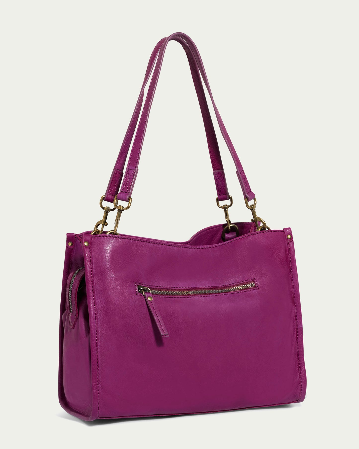 Introducing the Lenox Triple Entry Satchel by American Leather Co., a chic accessory crafted from genuine purple American leather. This satchel includes two shoulder straps and a front zipper pocket, highlighted with elegant gold-tone metal accents. Its minimalist design renders it an everyday essential, perfect against a plain, light background.